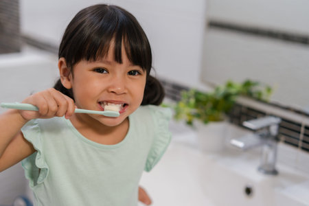 girl child brushing teeth in the bathroom