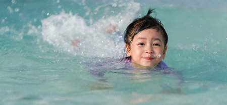 preschool child girl playing and swimming in the pool