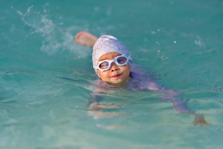 preschool child girl playing and swimming in the poolの写真素材