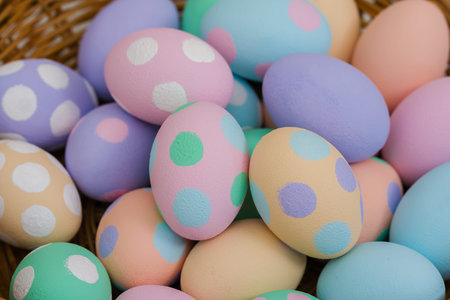 many colorful pastel decorated easter eggs in a small wooden basket