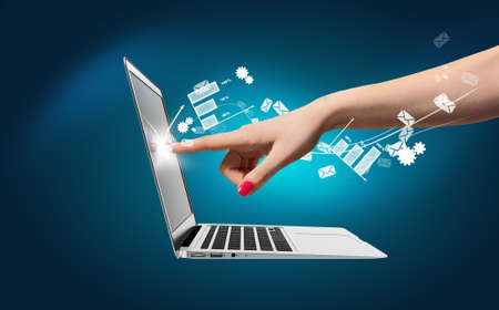 Hand of a young woman touch laptop screen icons around. Communication concept.の写真素材