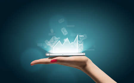 Hand with smartphone and business icons and graphicの写真素材