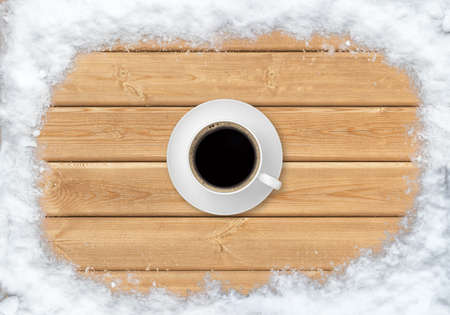 Top view of cup of hot coffee on clean wood planks with snowの写真素材