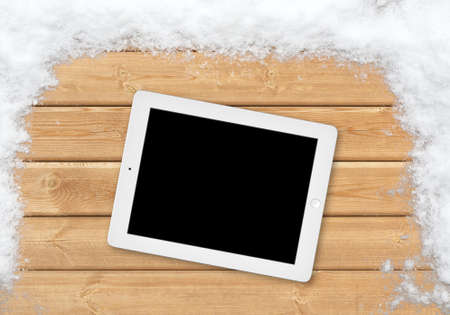 Top white wood office table with tablet and snowの写真素材