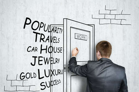 Businessman draws on concrete wall open door with flying off words.の写真素材