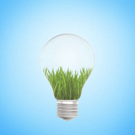 Green grass growing in a light bulb on a blue background