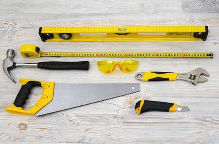 The top view of different working tools lying on wooden surface