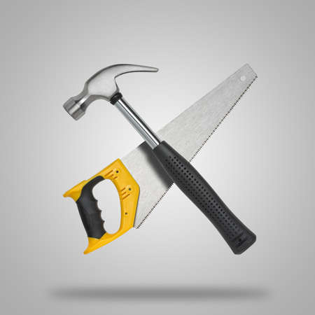 Crossed saw and hammer in gray background like iconの写真素材
