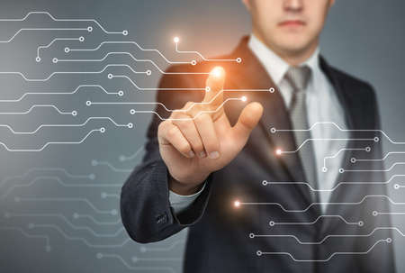 Business man touch digital icons and charts on a the holographic interface. Virtual technology conceptの写真素材