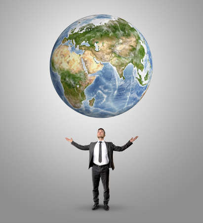 Businessman raised his hands to hold Earth looking at it.の写真素材