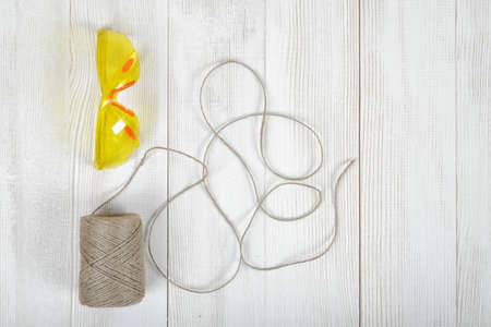 Art composition featuring of glasses and twine lying on white wooden surface. Top view.の写真素材