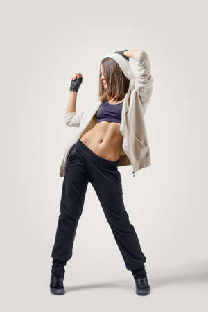Confident young girl dancer wearing sports jacket stands looking to the right sideの写真素材