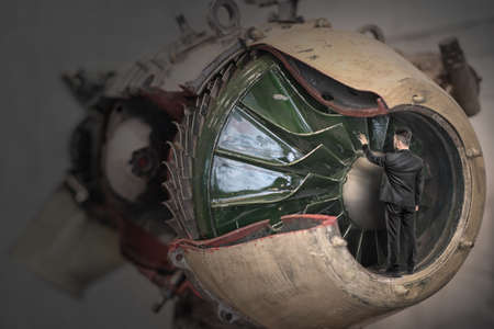 Man in a black suit touching big increased mechanism.の写真素材