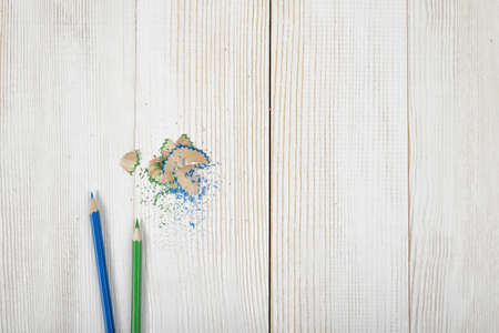 Green and blue colored pencils and its shavings on wooden plank. Designer work place.の写真素材