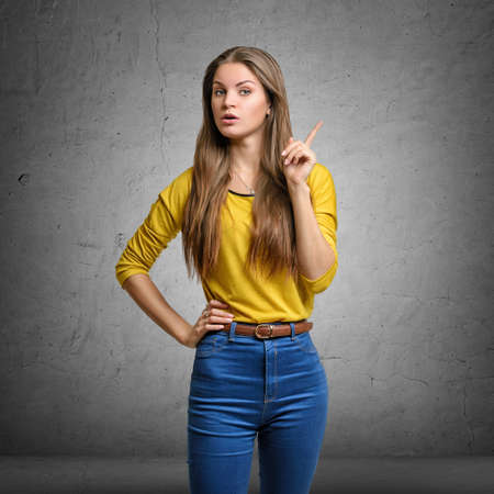 Threatening woman showing her index finger with serious expression to make a warning signの写真素材