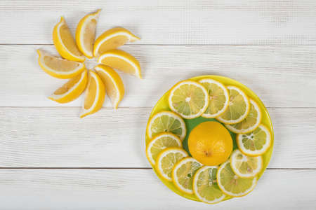 Citrus fruit slices arranged into a revolving shape. Lemon and orange are cut into slices and well decorated on a plate in top view.の写真素材