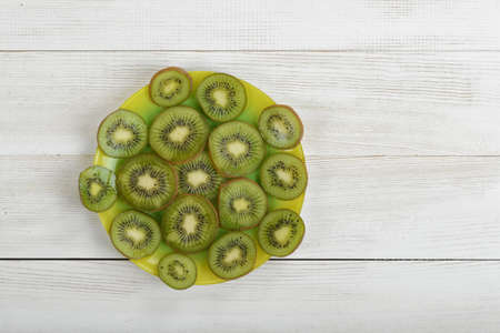 Dish full of kiwi slices in the center of image. Top view.の写真素材