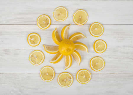 Flat lay of lemon pieces laid out into the sun shape and well decorated slices around it. Top view composition.の写真素材