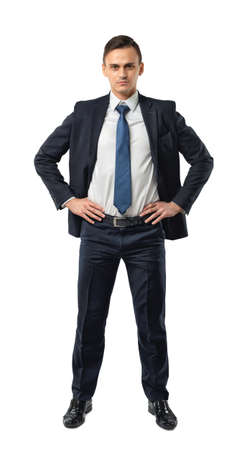 Cutout serious businessman holds his hands on his waist. Self-confidence. Strong commitment. Business staff. Office clothes. Dress code. Presentable appearance.の写真素材