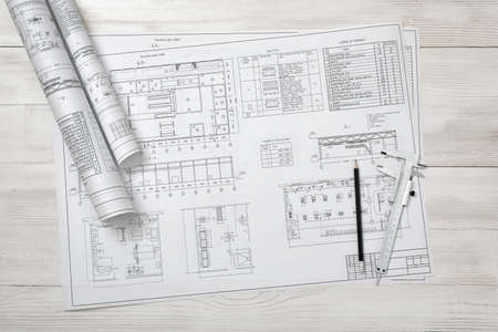 Rolls of drawing sketches lie on a wooden surface. Top view compositin. Workplace of architect or...