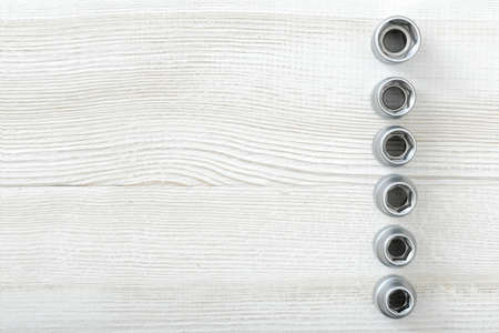 Layout with nuts distributed on wooden surface. Fasteners with threaded hole. Top view of construction tools. Mend and repair. Parts for repair. Fixing bolts.の写真素材