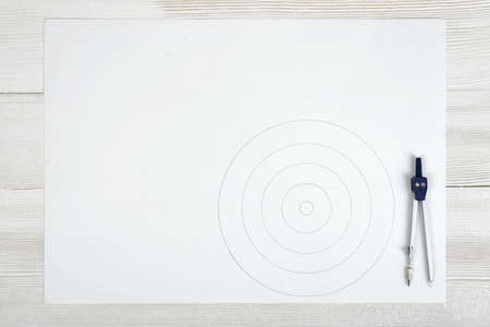 Engineering divider on a white paper with drawn circles. Top view composition. Workplace of...