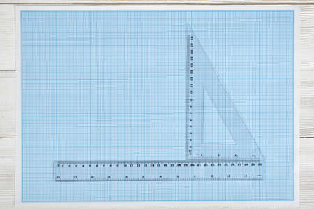 Triangle centimeter ruler and simple centimeter ruler on a blueprint. Top view composition. Measuring process. Work place of draftsman, architect, constructor. Engineering work. Construction and architecture. Architect drawing. Measurement.の写真素材
