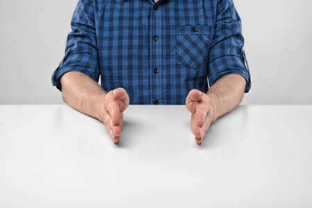 Close-up hands of man showing small size of something. Symbols and gestures. Imitation. Concept. Body language. Cropped portrait. Hand gesture.の写真素材