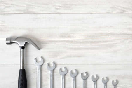 Top view of construction tools including hammer and different sized wrenches on wooden surface with open space. Tools for carpentry work. Type of fastener. Hexagonal shape. Mend and repair. Parts for repair.の写真素材