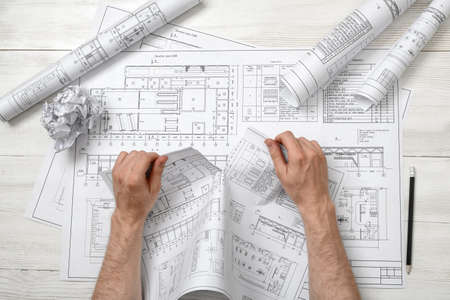 Close-up hands of architect tearing a bad architect drawing. Anger sign. Worry process. Nervous...
