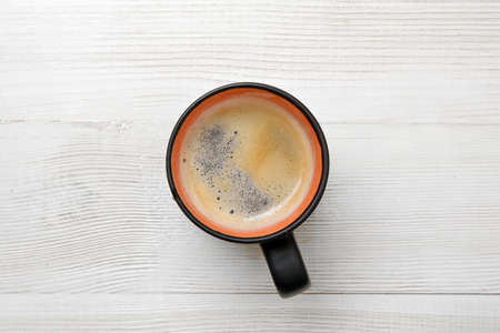 Cup of hot coffee on a wooden surface. Top view. Workplace of office man. Willingness to work overtime. Increasing productivity in the mornings. Improving mood and productivity. Coffee breakfast.の写真素材