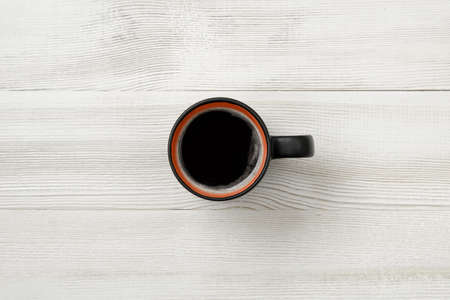 Cup of hot coffee on a wooden surface. Top view. Workplace of office man. Willingness to work overtime.  Increasing productivity in the mornings. Improving mood and productivity. Coffee breakfast.の写真素材