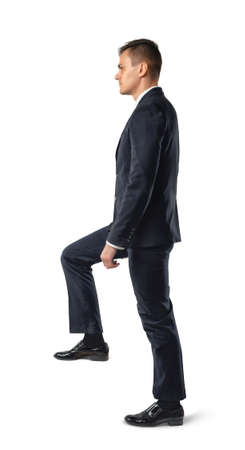 Side view of businessman climbing stairs , isolated on white background. Business staff. Office clothes. Dress code. Presentable appearance. Self-confidence.の写真素材