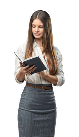 Cutout business woman holding and looking in notebook. Smart staff. Success and development. Business staff. Office clothes. Learning and teaching. Study process.の写真素材