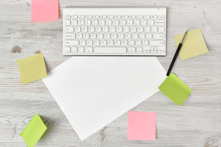 Stickers, keyboard, pencil and white blank paper in top view. Workplace of office man. Office stuff. Poor memory reminders. Organizer. Things for the convenience of work at home.の写真素材
