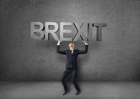 Businessman holding heavy 3d 'brexit' word over his head.の写真素材