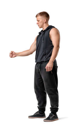 Side view of handsome muscled young man holding something isolated on white background. Fitness, sport, bodybuilding, workout. Self improvement.の写真素材