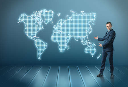 Businessman stands showing world map by both hands. Business staff. World of possibilities. Global communication.の写真素材