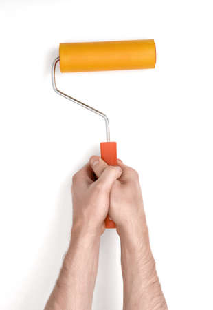 Close-up hands of man holding a paint roller.の写真素材