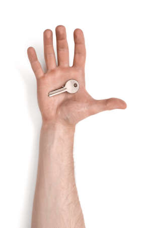Close up view of a man's hand with a key isolated on white background.の写真素材