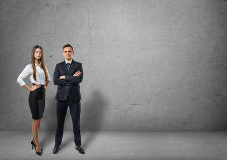 Front view of a businessman and a businesswoman standing side by side on the background of a...