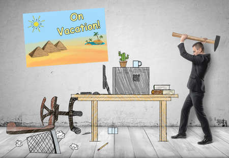 Businessman smashing his workplace with hammer with 'on vacation!' poster on the wall.の写真素材