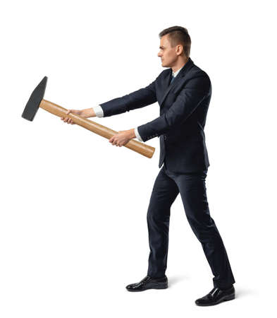 Side view of a businessman with big hammer in his arms destroying something, isolated on white background.の写真素材