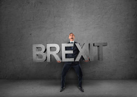 Businessman holding heavy 3d 'brexit' wordの写真素材