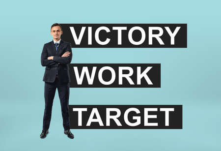 Front view of a businessman standing confidently with a motto 'victory work target' behind him....