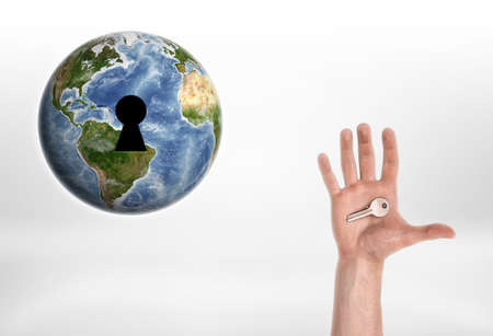Human hand with the key from planet Earth. Enviroment protection. Protection of Nature. Resource usage. Elements of this image are furnished by NASA.の写真素材