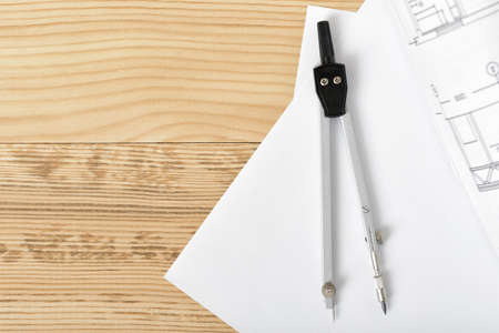 Compass on white paper in top view with copy space on the left side. Workplace of architect,...