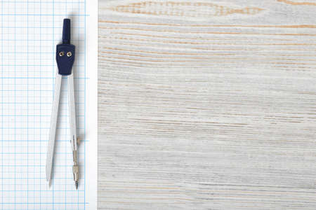 Compass on graph paper in top view with copy space on the right side. Workplace of architect, constructor, designer. Start a new project. Construction and architecture. Tools for drawing.の写真素材