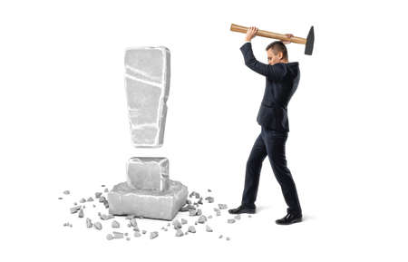 Businessman is breaking gray stone using hammer on white backgroundの写真素材