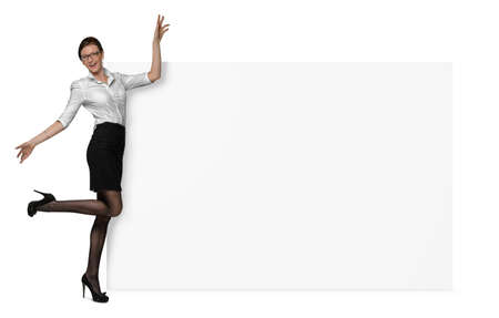 Happy woman in official clothing is holding a side of a blank banner isolated on white backgroundの写真素材